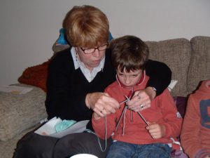 Grandmother showing grandson how to knit