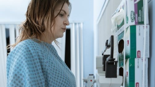 female in hospital gown on weighing scales