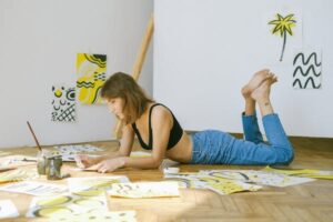 female on floor doing art