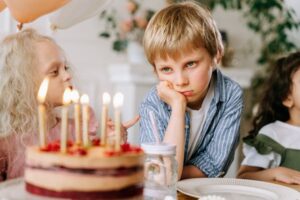 child looking sad at birthday party