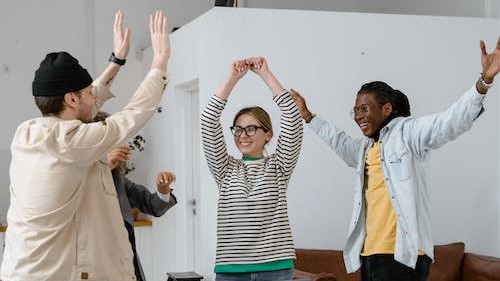 4 people celebrating with arms in the air