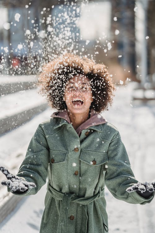 female throwing snow in the air