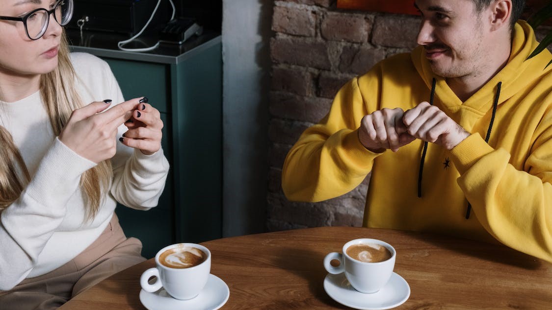2 people sitting at a table with coffee