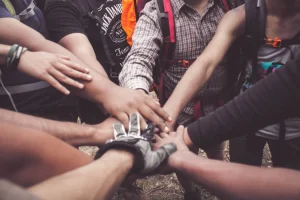 many people putting hands into a circle